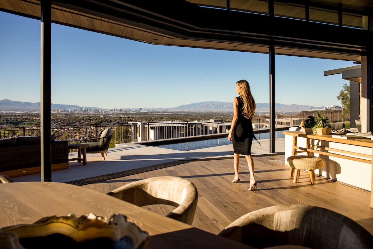 Woman enjoying panoramic city view from luxury terrace.