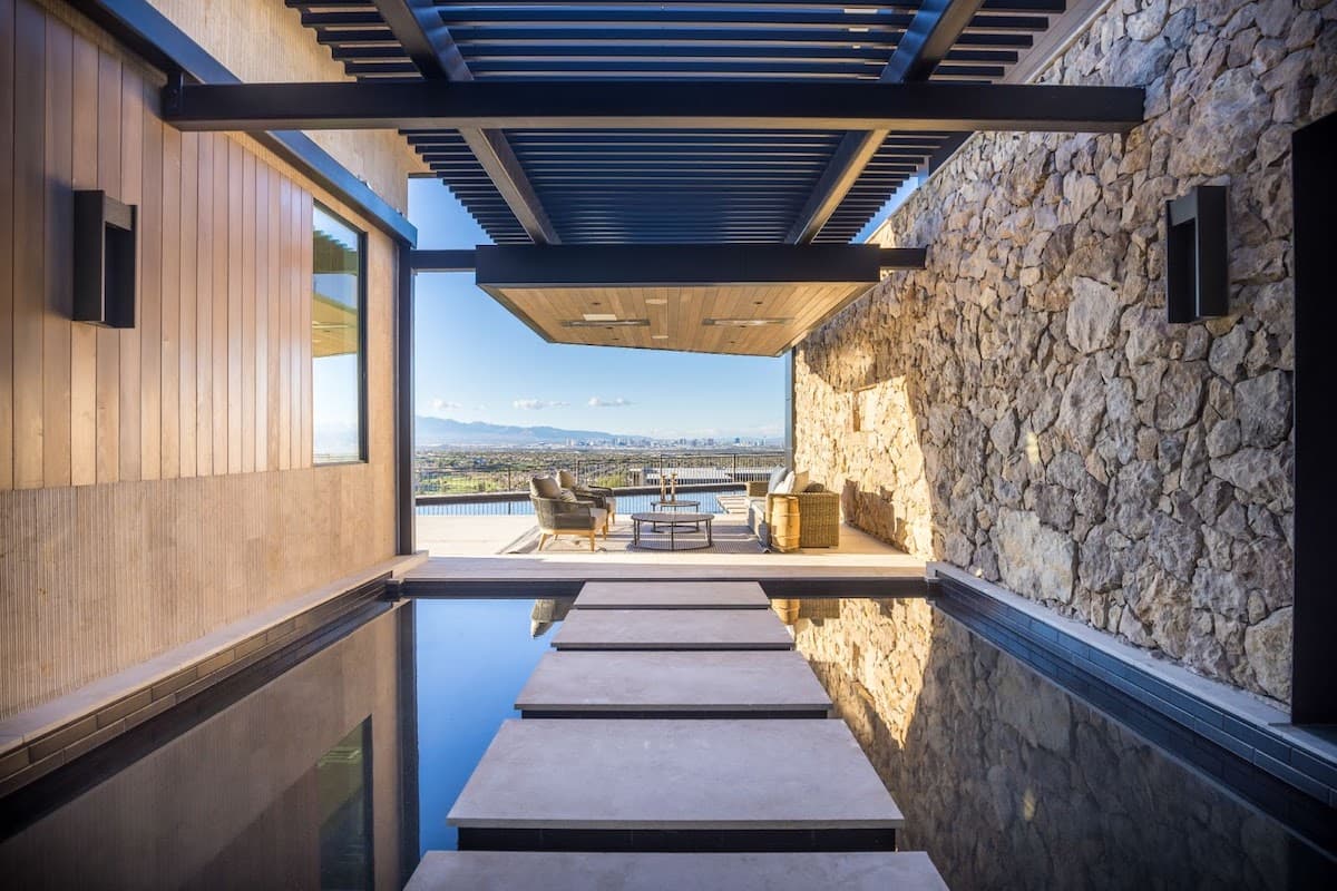 Modern luxury home hallway with reflecting pool and mountain view.