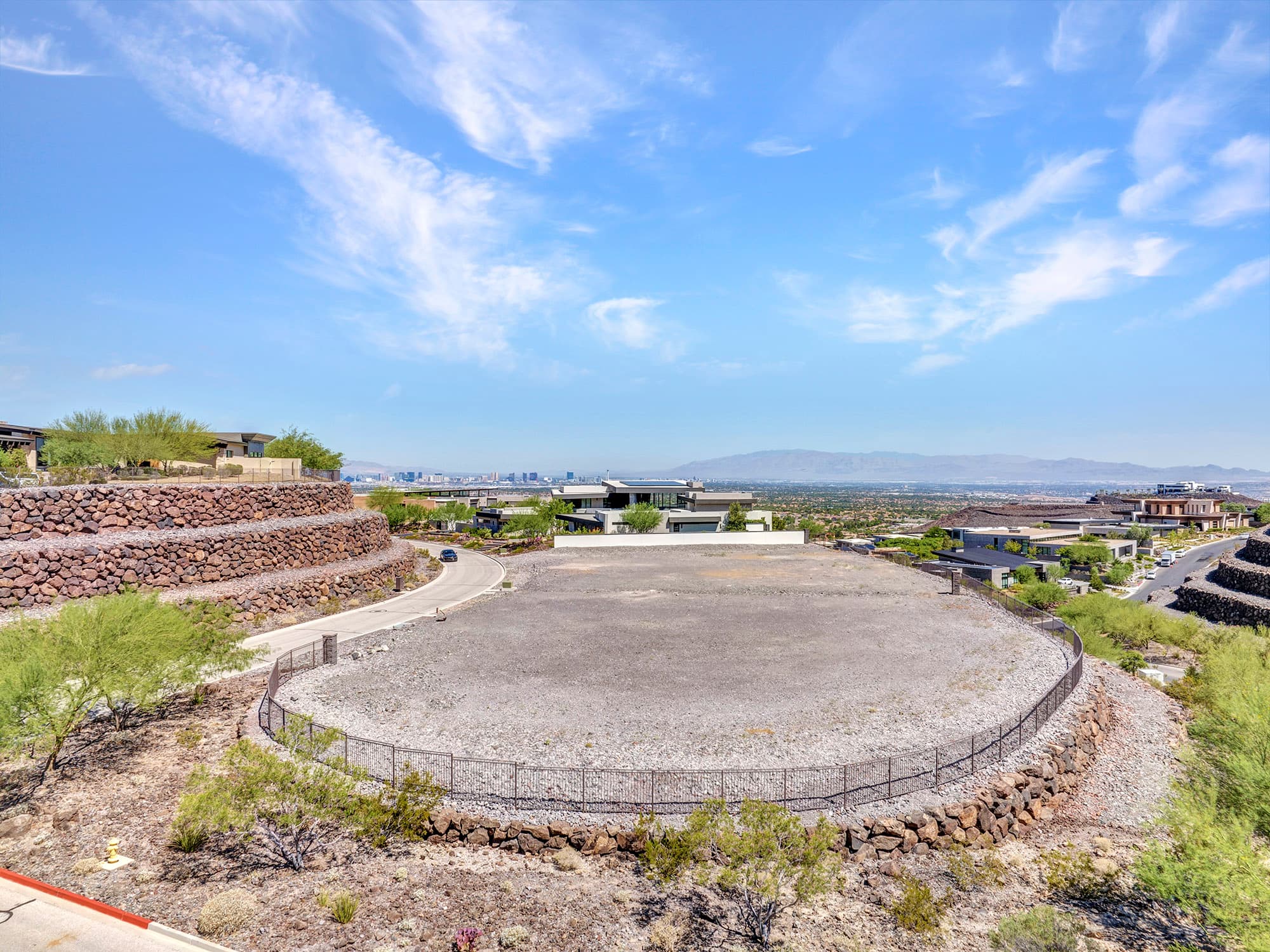 Corner homesite with expansive Las Vegas Valley views, terraced desert landscaping, and surrounding custom residences at Ascaya.