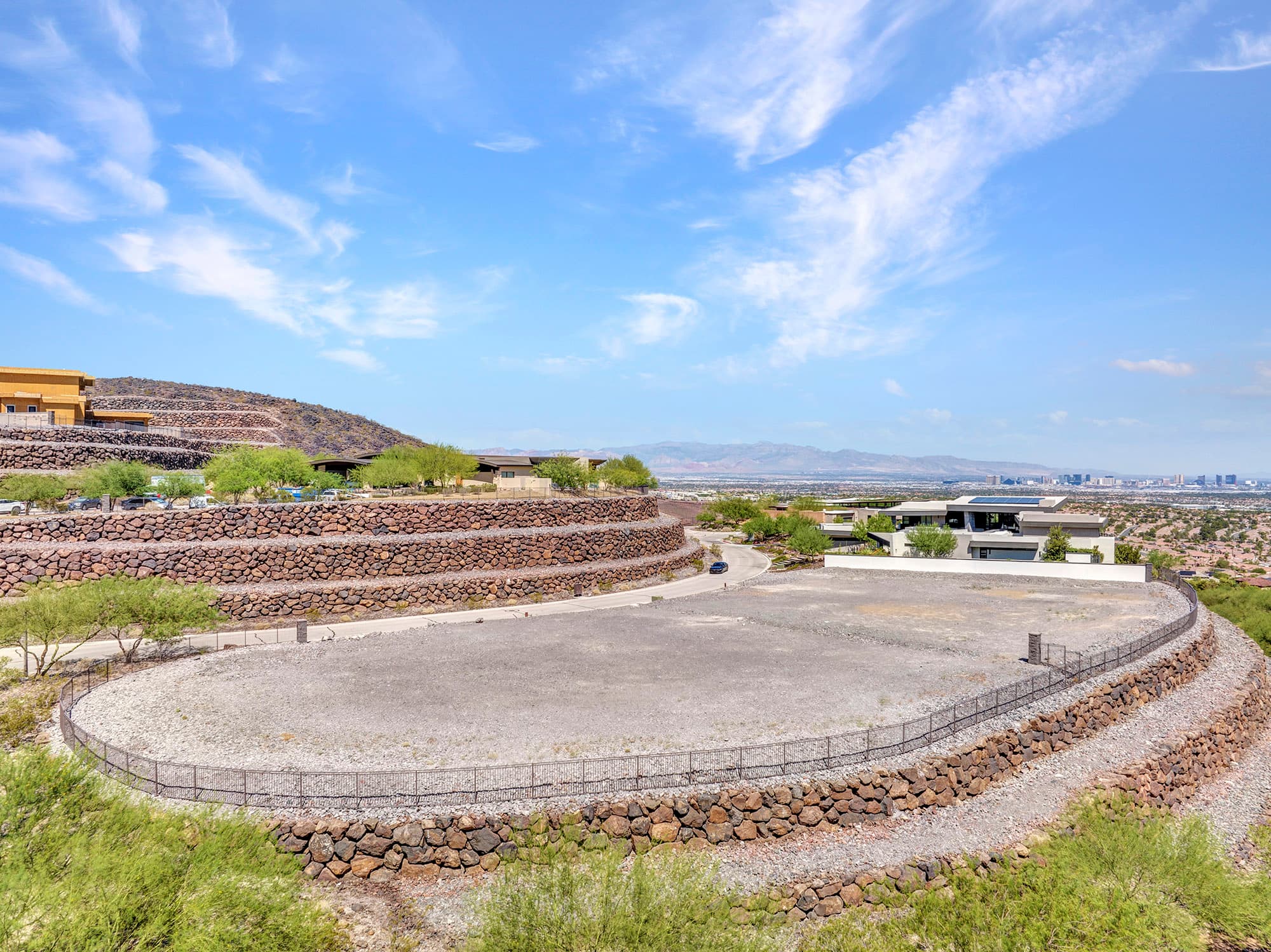 Aerial view of a terraced homesite at Ascaya with panoramic views of the Las Vegas Valley, surrounding mountains, and signature stone retaining walls.