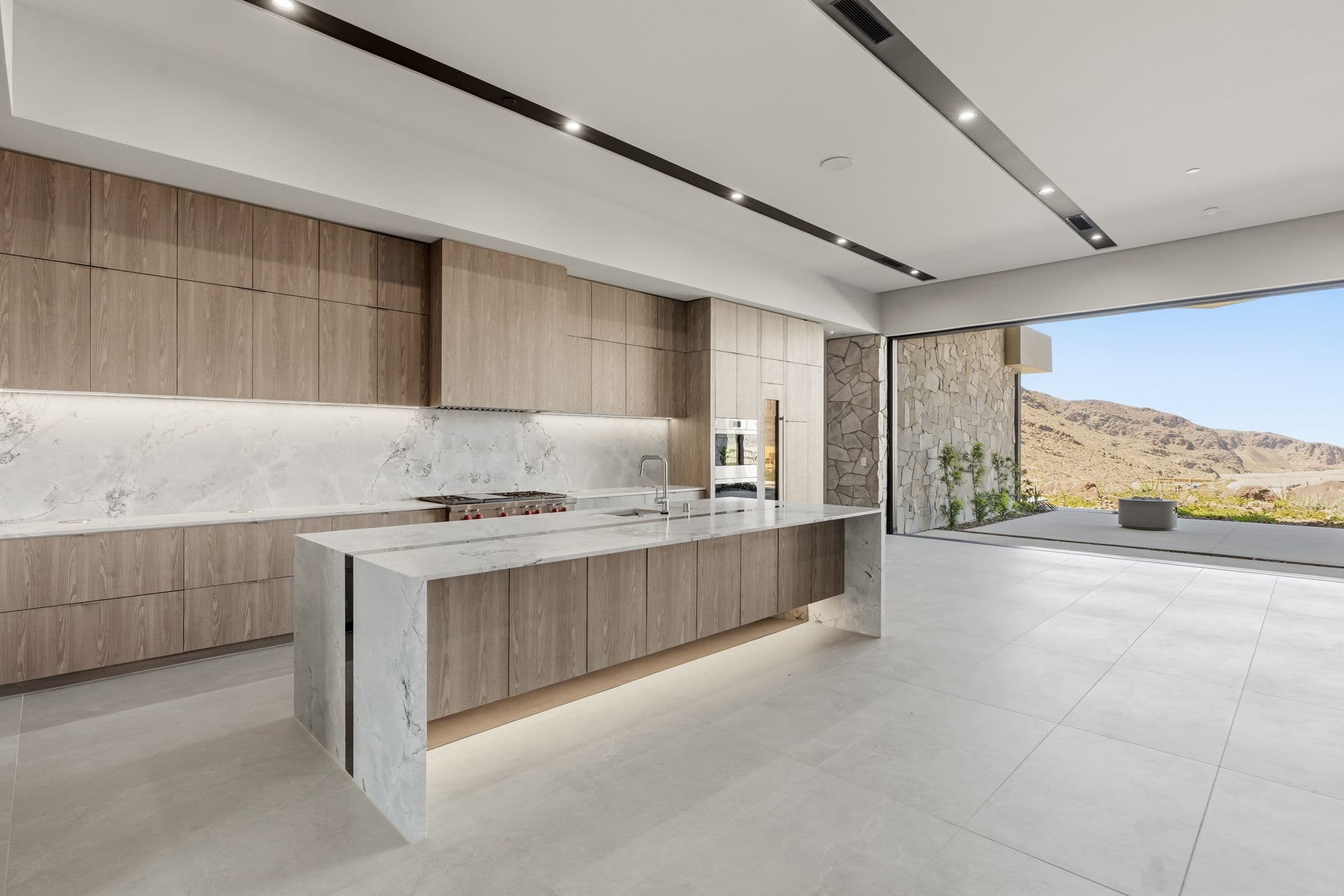 Modern luxury residence with contemporary architecture, open-concept living spaces, high-end finishes, expansive windows, and seamless indoor-outdoor design set against scenic desert mountain views.