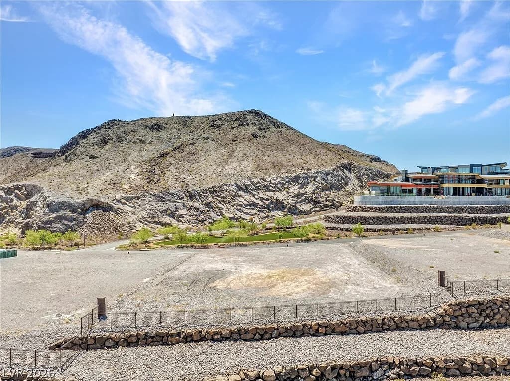 Level estate homesite at Ascaya with terraced stone retaining walls and adjacent modern desert architecture.
