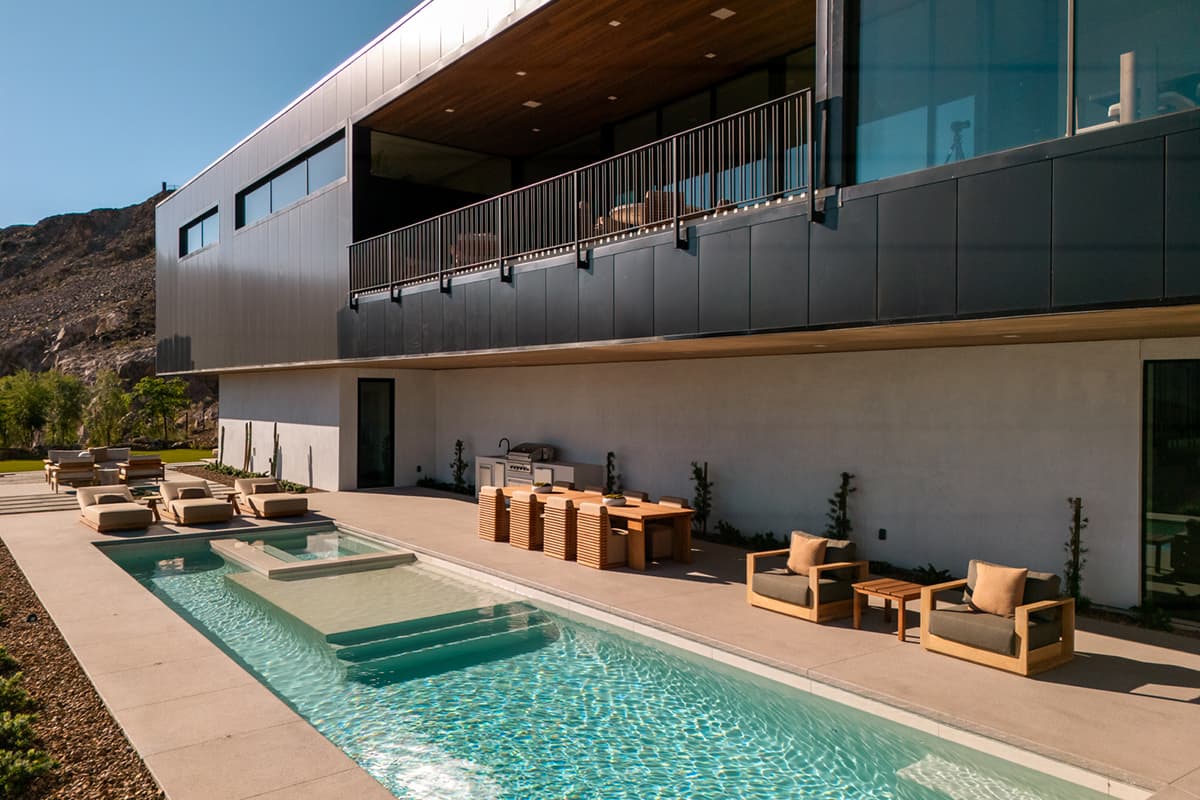 Modern Ascaya outdoor living space with resort-style pool, spa, and covered terrace