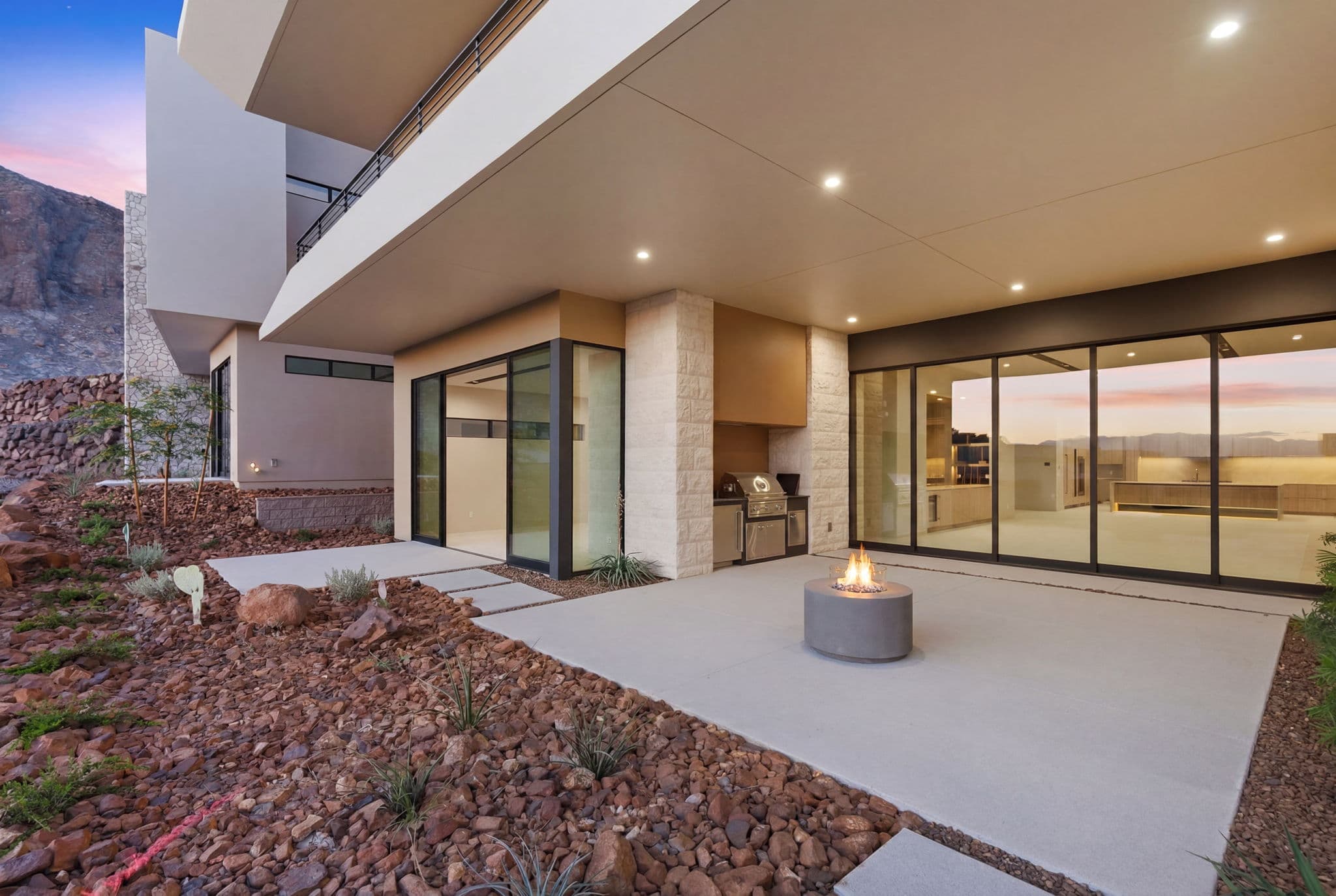 Private outdoor living space with built-in barbecue, fire feature, covered patio, and seamless connection to the interior living areas