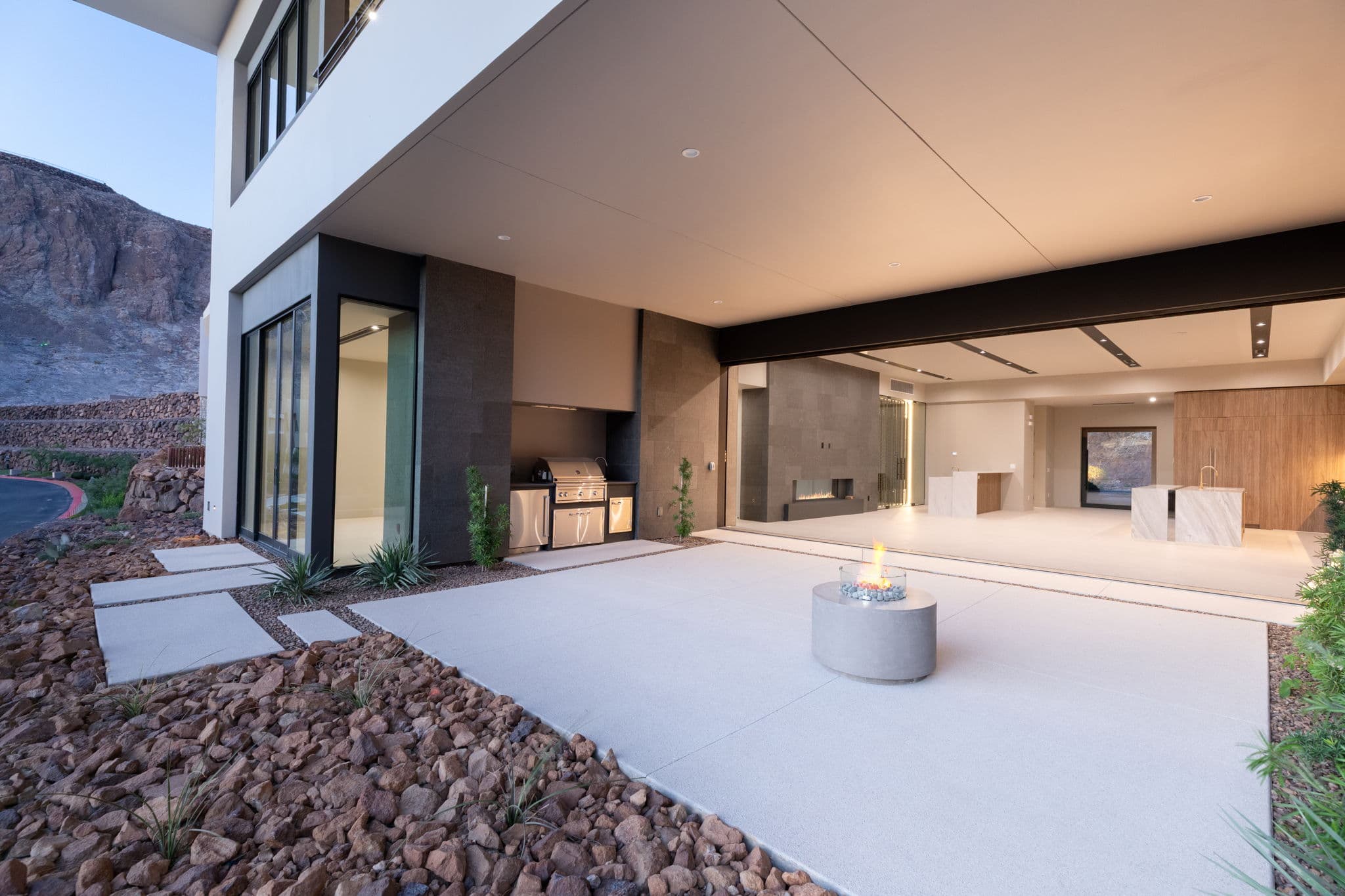 Private outdoor courtyard with covered lounge area, built-in grill, and seamless connection to the interior living space