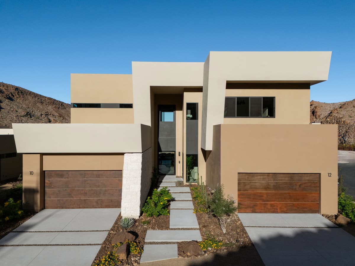 Contemporary desert homes with minimalist architecture, landscaped xeriscape gardens, and scenic mountain backdrop in a luxury residential community.