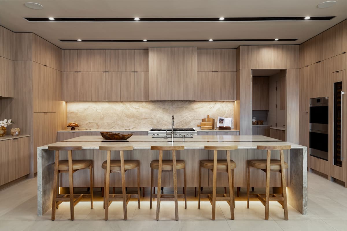 Minimalist luxury kitchen in Ascaya with natural stone finishes and custom wood cabinetry