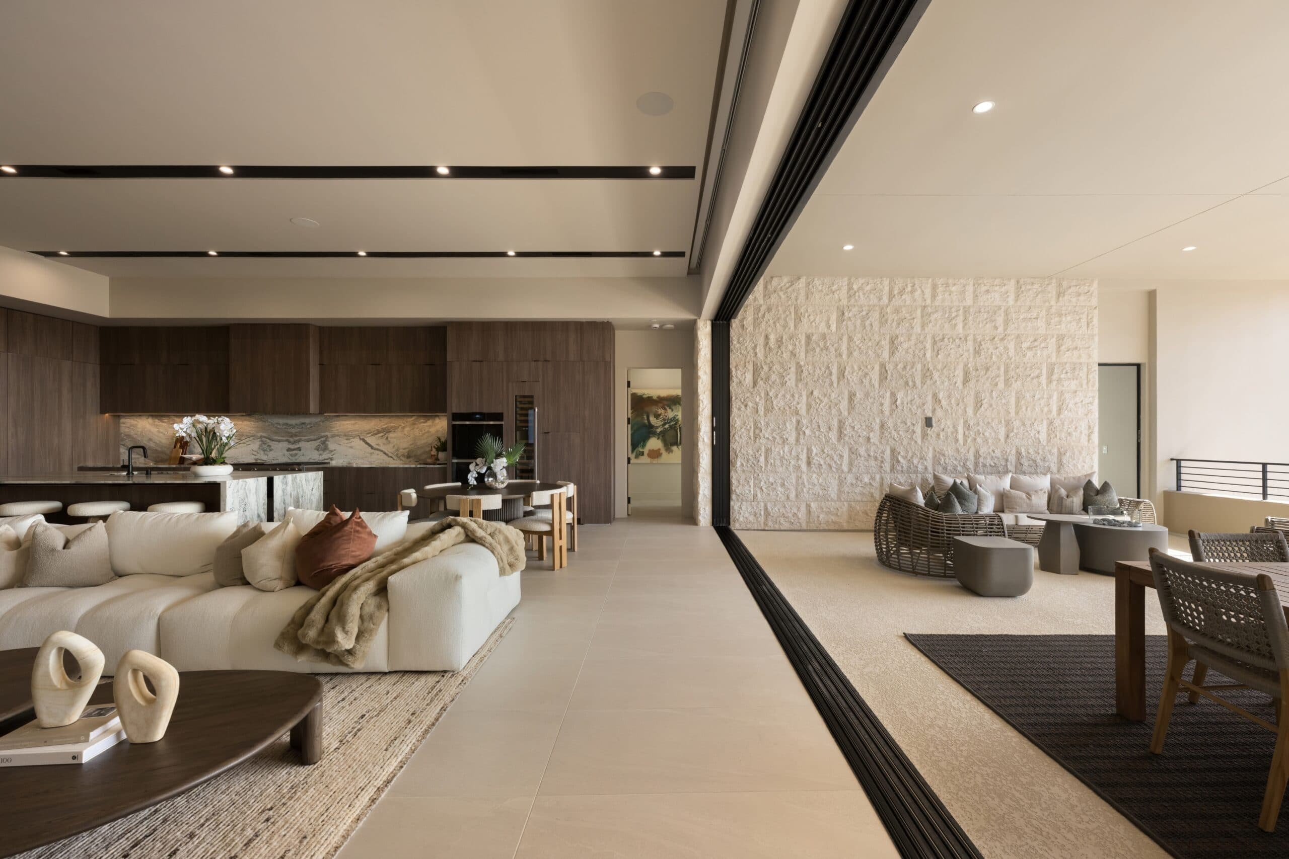 Luxury open-concept living space with a modern kitchen, elegant neutral furnishings, and seamless indoor-outdoor entertaining areas.