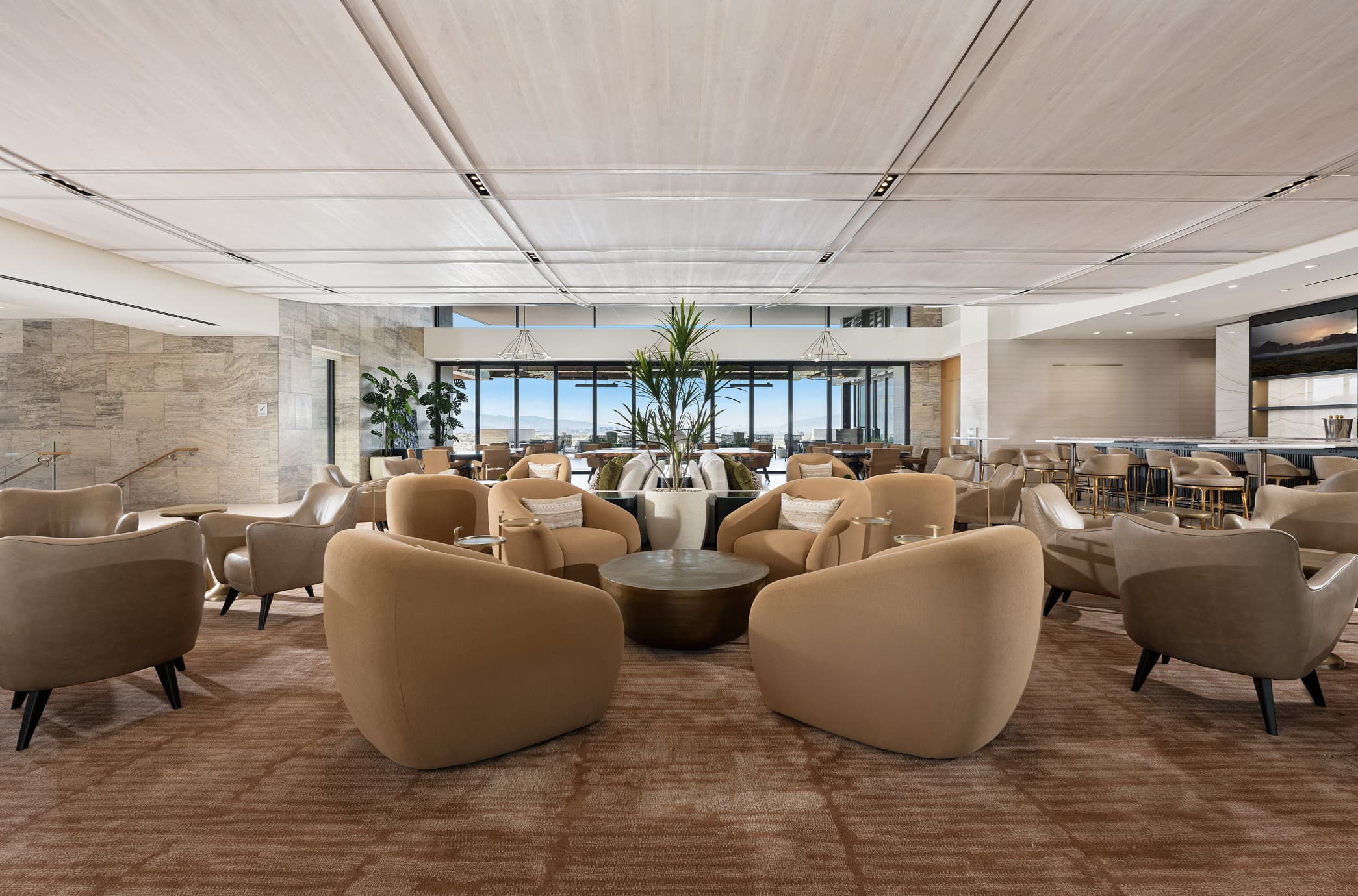 Modern luxury clubhouse lounge with plush seating, neutral interiors, and panoramic outdoor views.