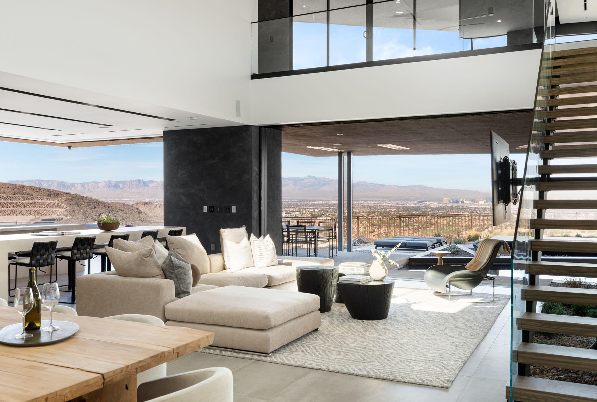 Open-concept luxury living space in Ascaya with panoramic Las Vegas Strip views, floating staircase, and seamless indoor-outdoor design