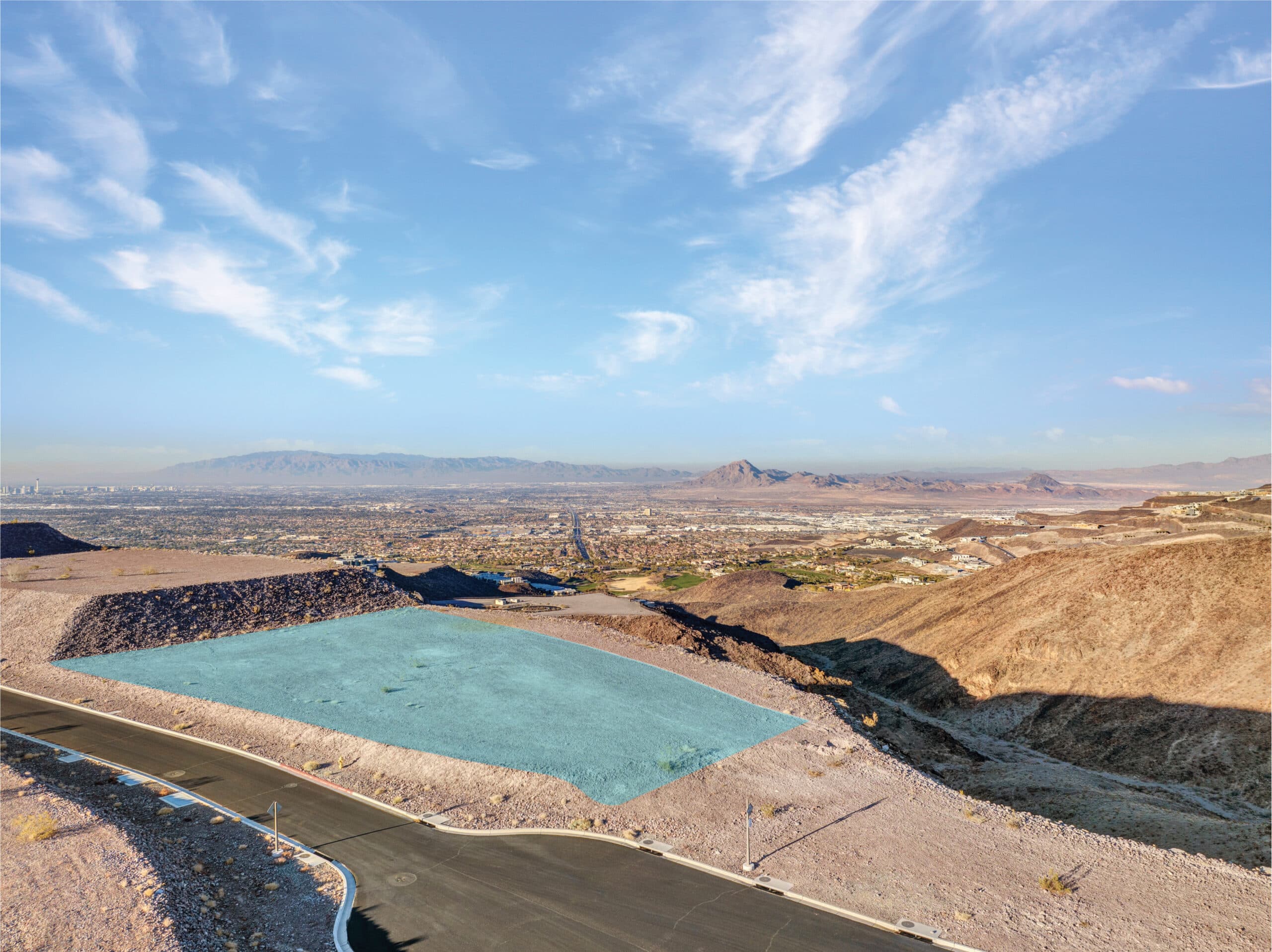 Aerial view of a modern hillside residential development in a desert landscape.