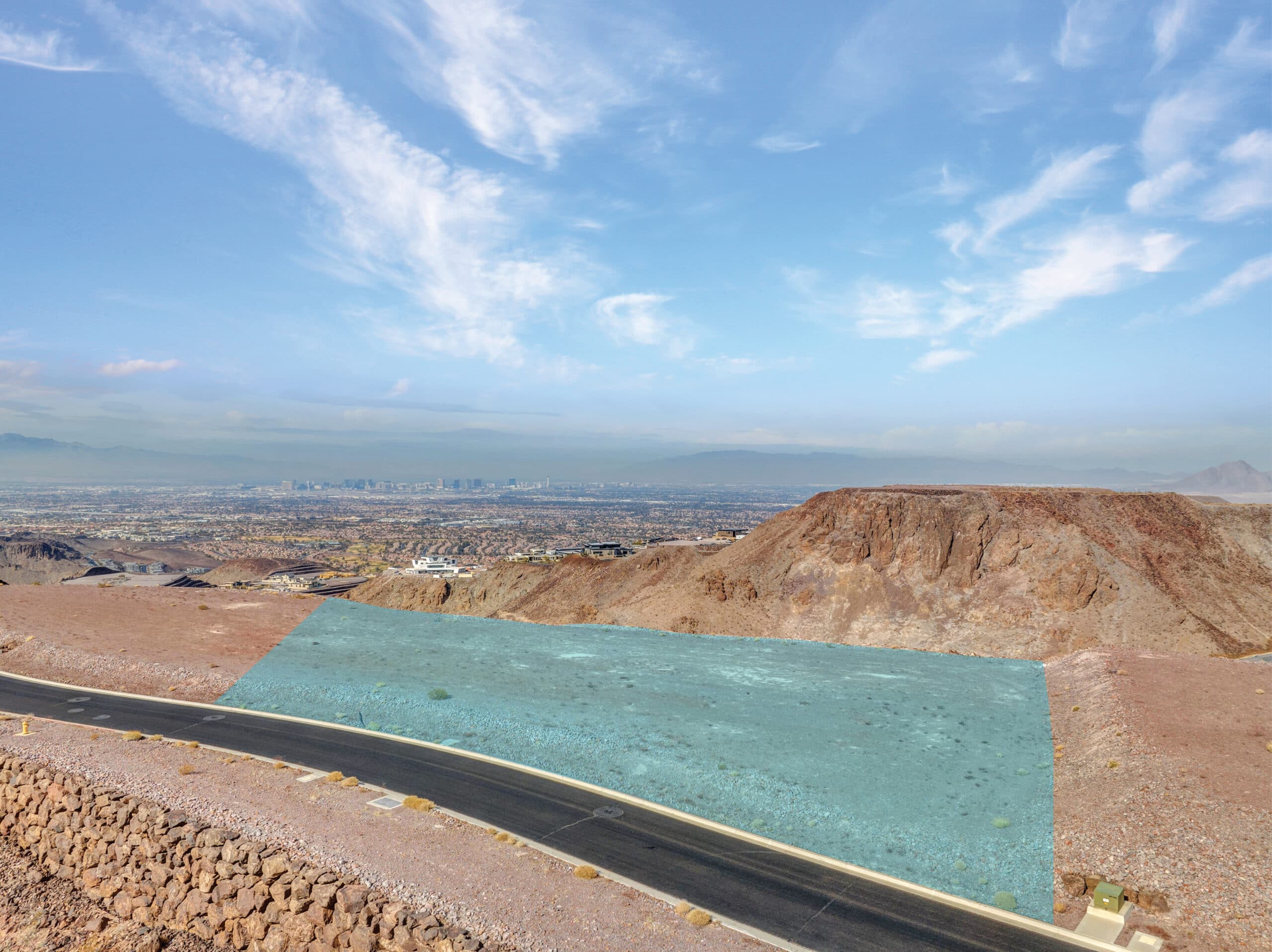 Aerial view of a modern hillside residential development in a desert landscape.
