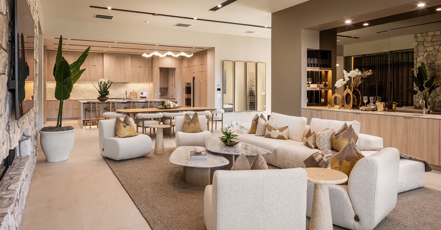 Luxury open-concept living room and kitchen with modern furnishings, neutral tones, and upscale interior design.