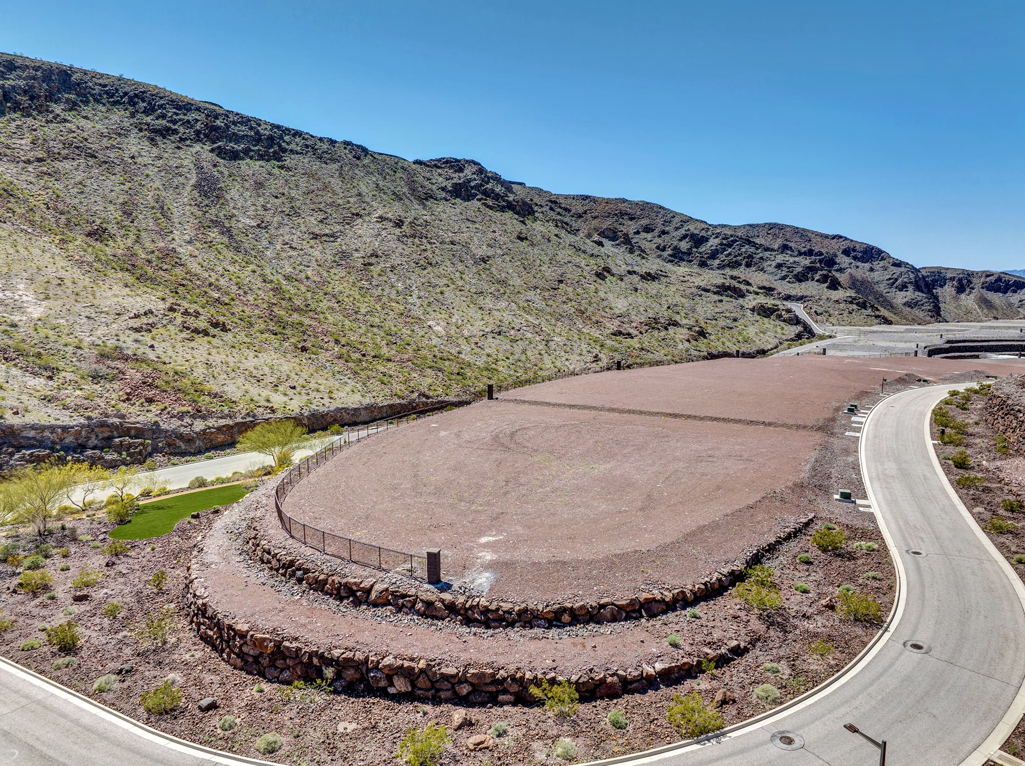 Aerial view of homesite lot outlined within a desert mountainside community development