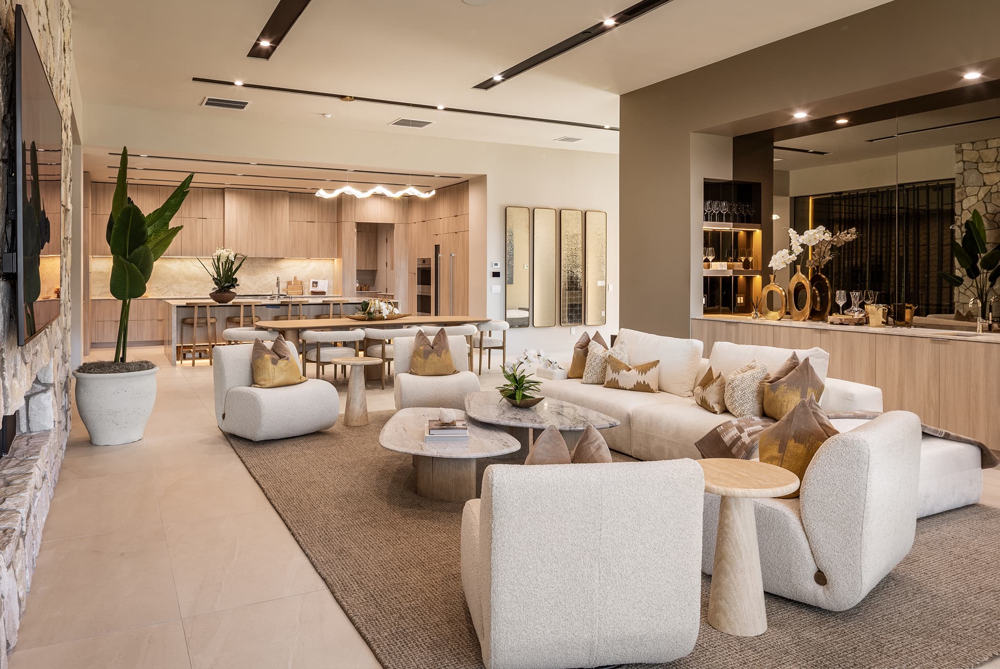 Luxury open-concept living room and kitchen with modern furnishings, neutral tones, and upscale interior design.