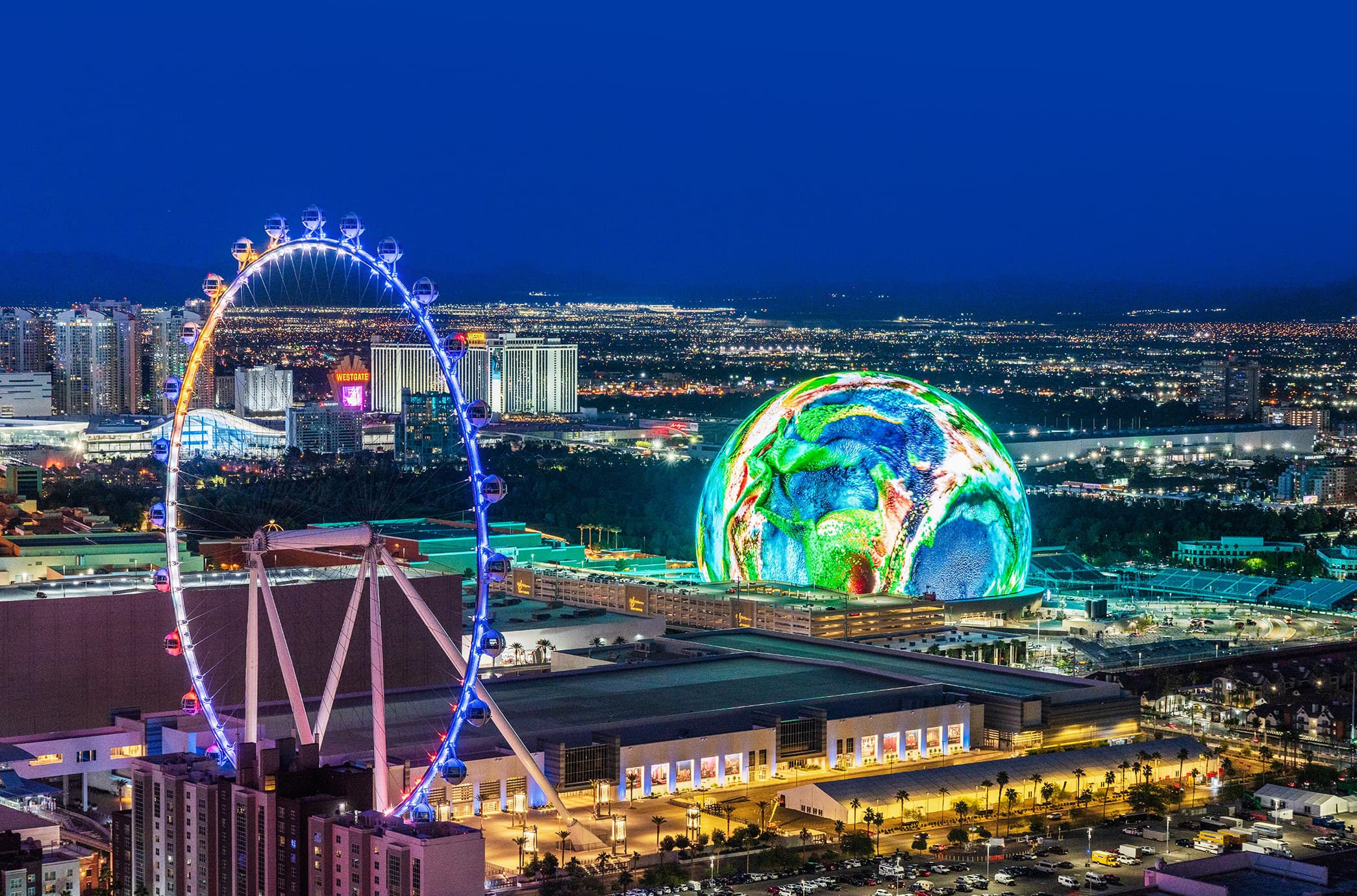 Las Vegas skyline at night featuring the High Roller observation wheel and the illuminated Sphere, highlighting the city’s vibrant entertainment and nightlife scene.